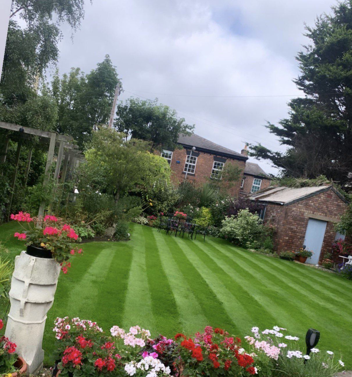 Striped lawn and flower borders after regular mowing by AJ Garden Services